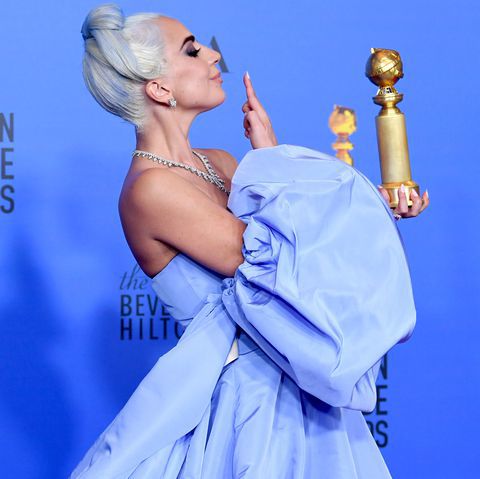 Lady Gaga holding her golden globe and looking like an absolute goddess